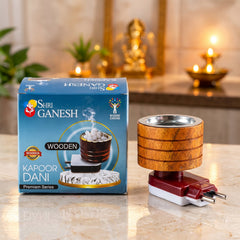 A wooden electric camphor diffuser with a metal cup stands next to its blue and white product box.