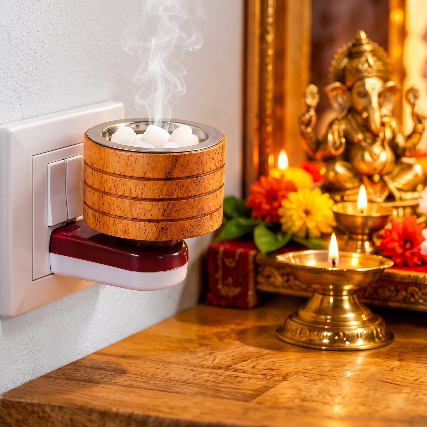 A wooden electric camphor diffuser plugged into a wall socket emits smoke, with a golden Ganesha idol nearby.