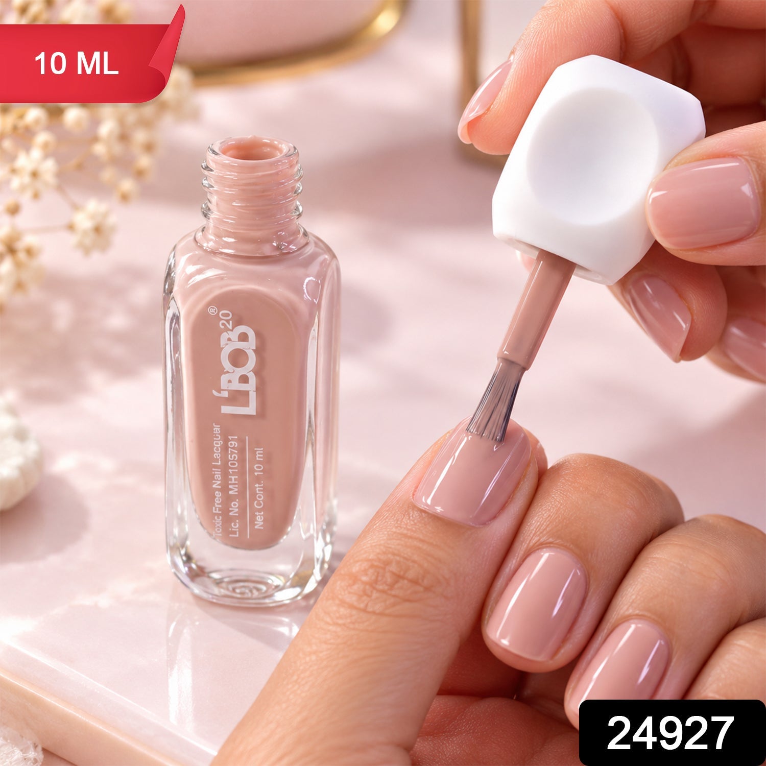 A hand applies nude pink nail polish to a fingernail, with an open bottle beside it, and a red 10 ML label.