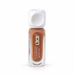 A clear glass bottle of nude brown nail polish with a white square cap stands upright.