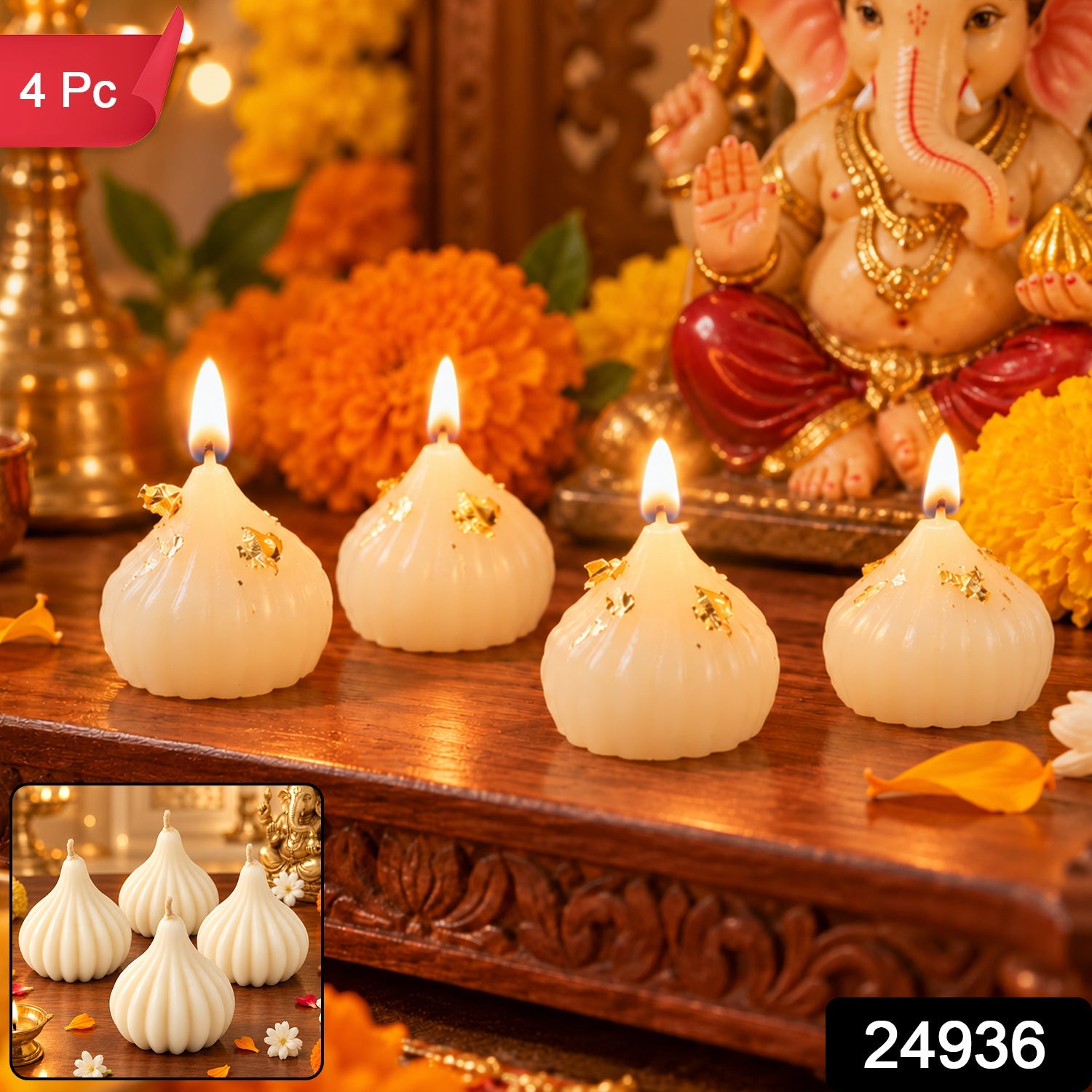 Four lit white modak-shaped candles with gold flakes on a wooden table, with a Ganesha statue and flowers behind them.