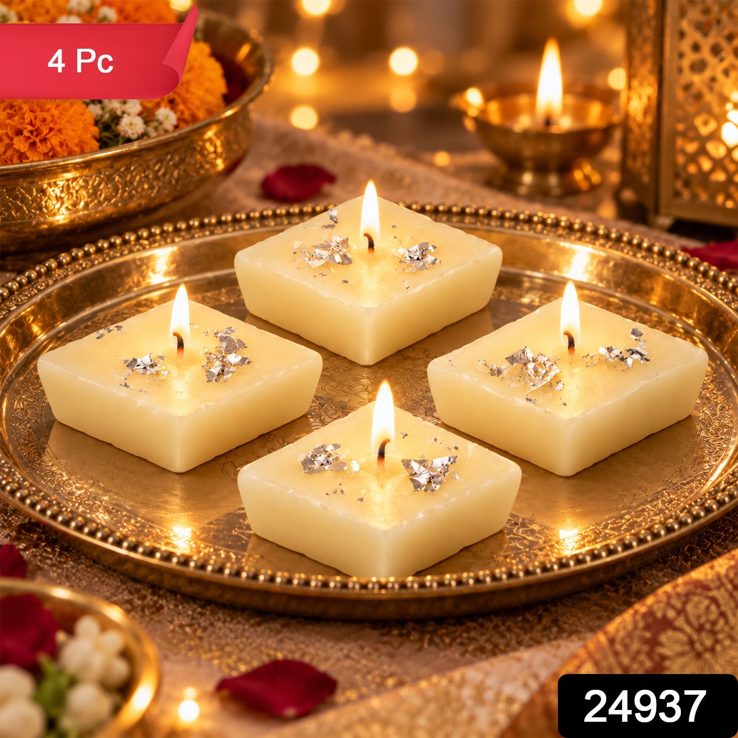 Four unlit diamond-shaped cream candles with silver foil accents on a gold ornate tray, with a blurred background of lights