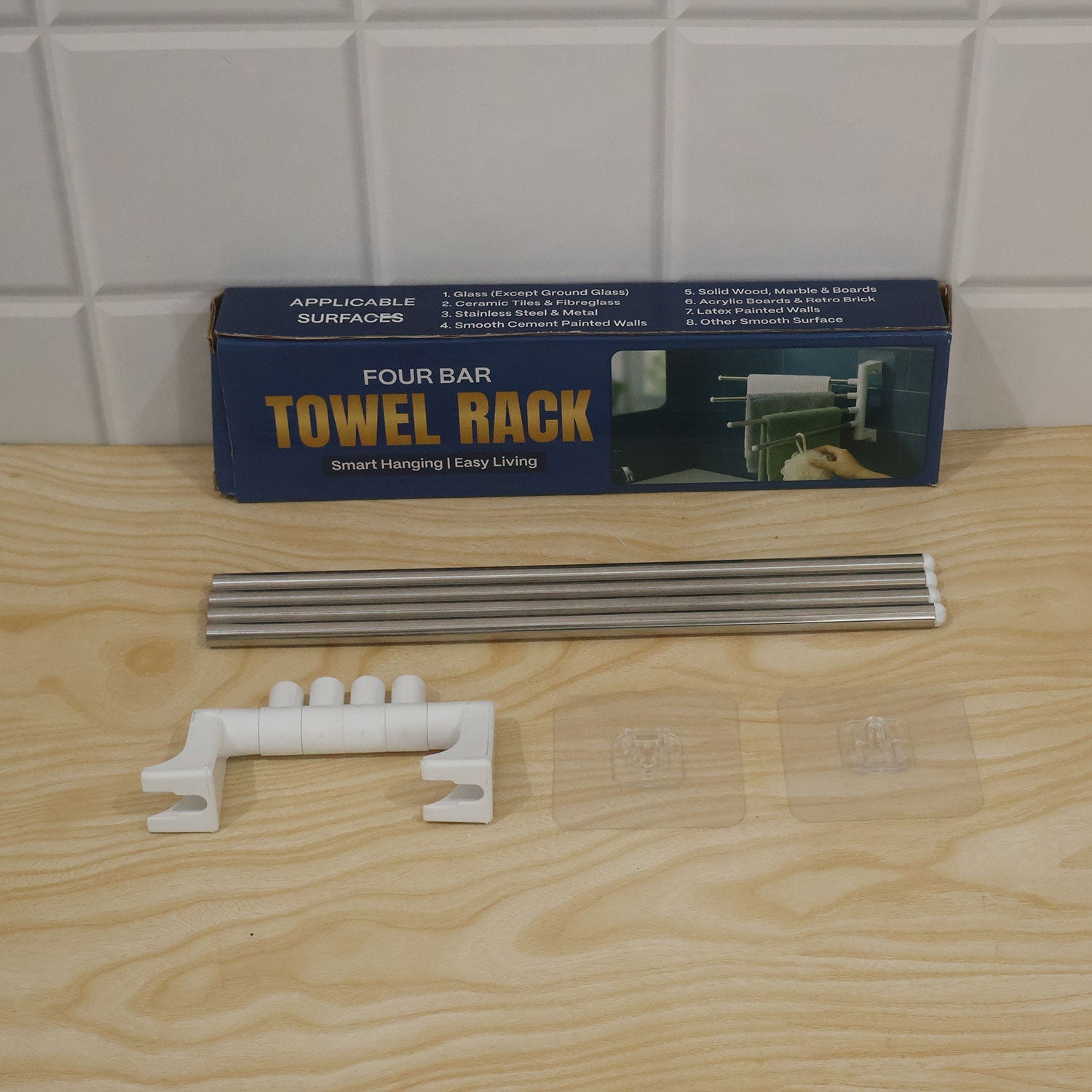The disassembled towel rack components are displayed next to its blue packaging box on a wooden surface.