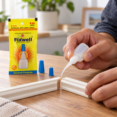 A person applies clear glue from a small white bottle with a fine nozzle to join two pieces of white molding on a wooden
