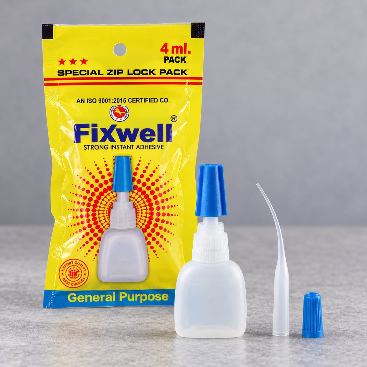 A yellow Fixwell glue packet stands behind a small white glue bottle with a blue cap, a fine extension nozzle, and an extra
