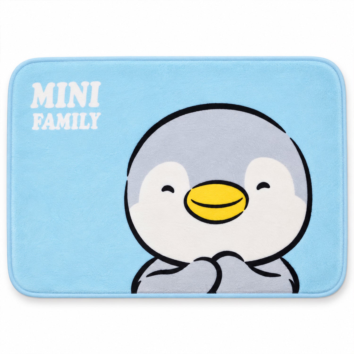 A rectangular light blue bath mat displays a large, happy cartoon penguin with the words "MINI FAMILY".