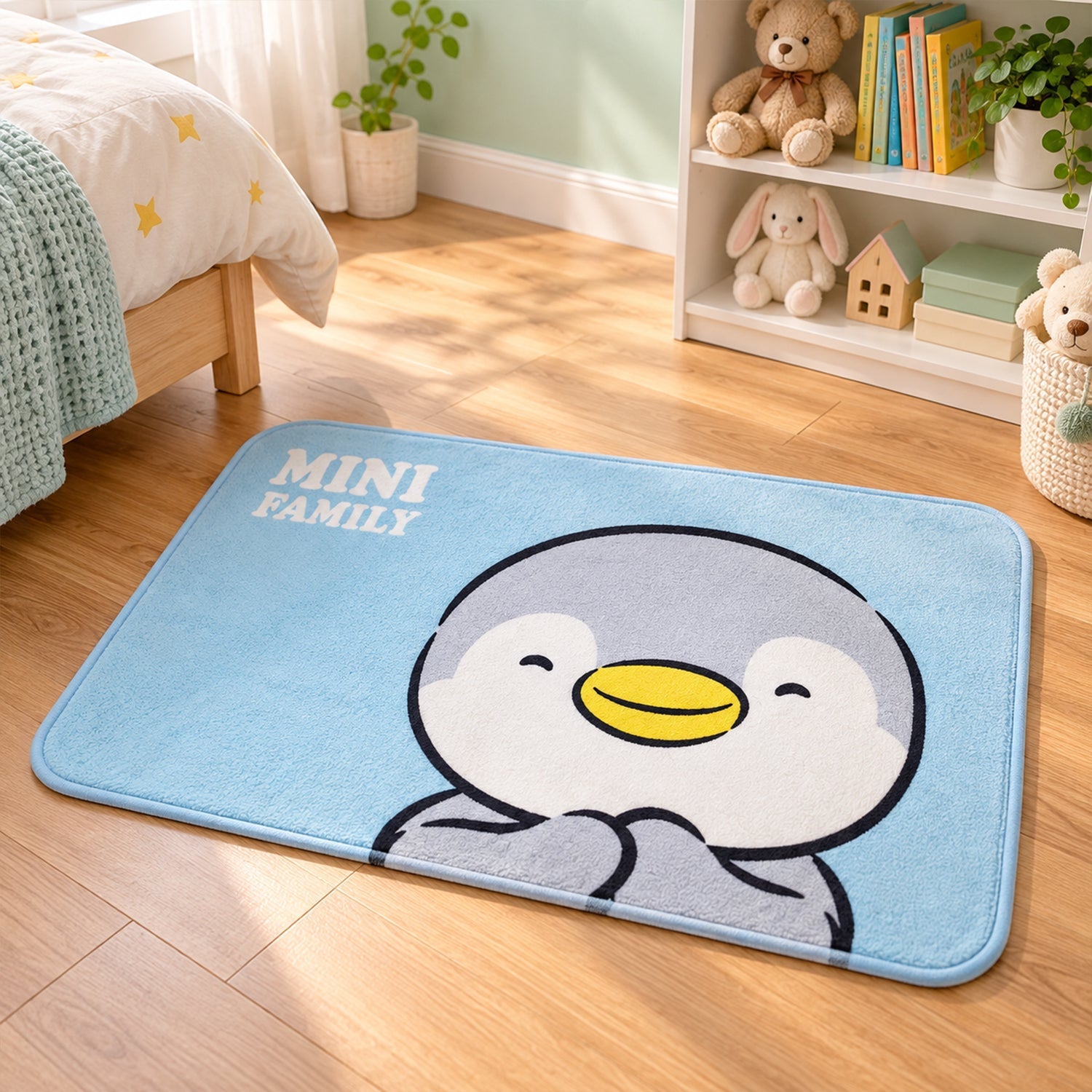 A blue bath mat with a smiling penguin design lies on a wooden floor in a child's bedroom with toys nearby.