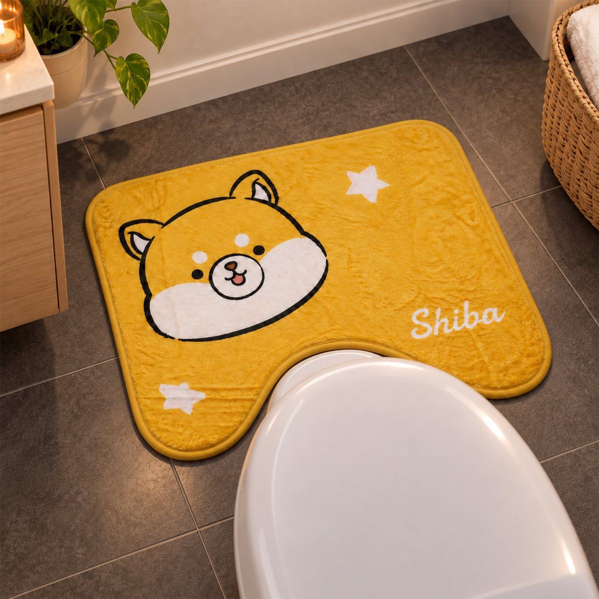 A yellow U-shaped toilet mat with a cartoon Shiba Inu face and white stars, placed on a grey tiled bathroom floor.
