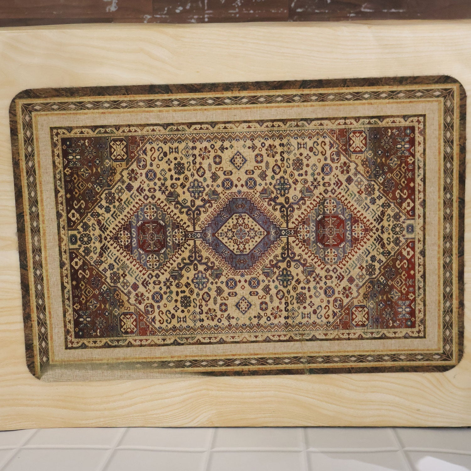 The decorative floor mat is displayed flat on a light wood surface, angled slightly to the left.