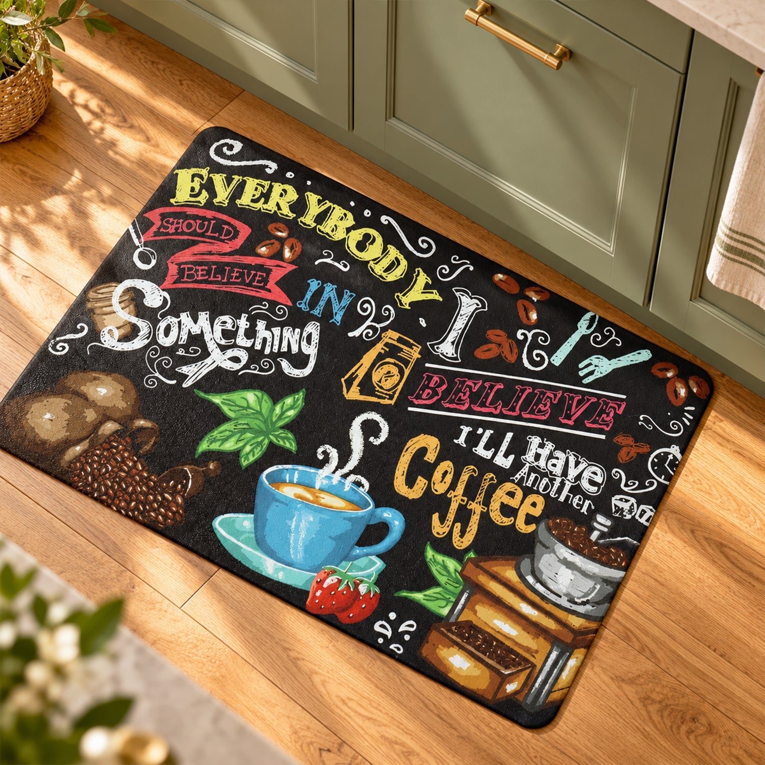 Coffee-themed mat on a wooden floor in a kitchen with green lower cabinets and a hanging towel.