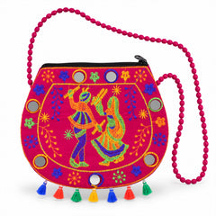 A vibrant pink sling bag with embroidered dancers, mirrors, and colorful tassels on a white background.