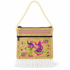 A beige jute sling bag with colorful embroidery, gold sequins, and white fringe on a white background.