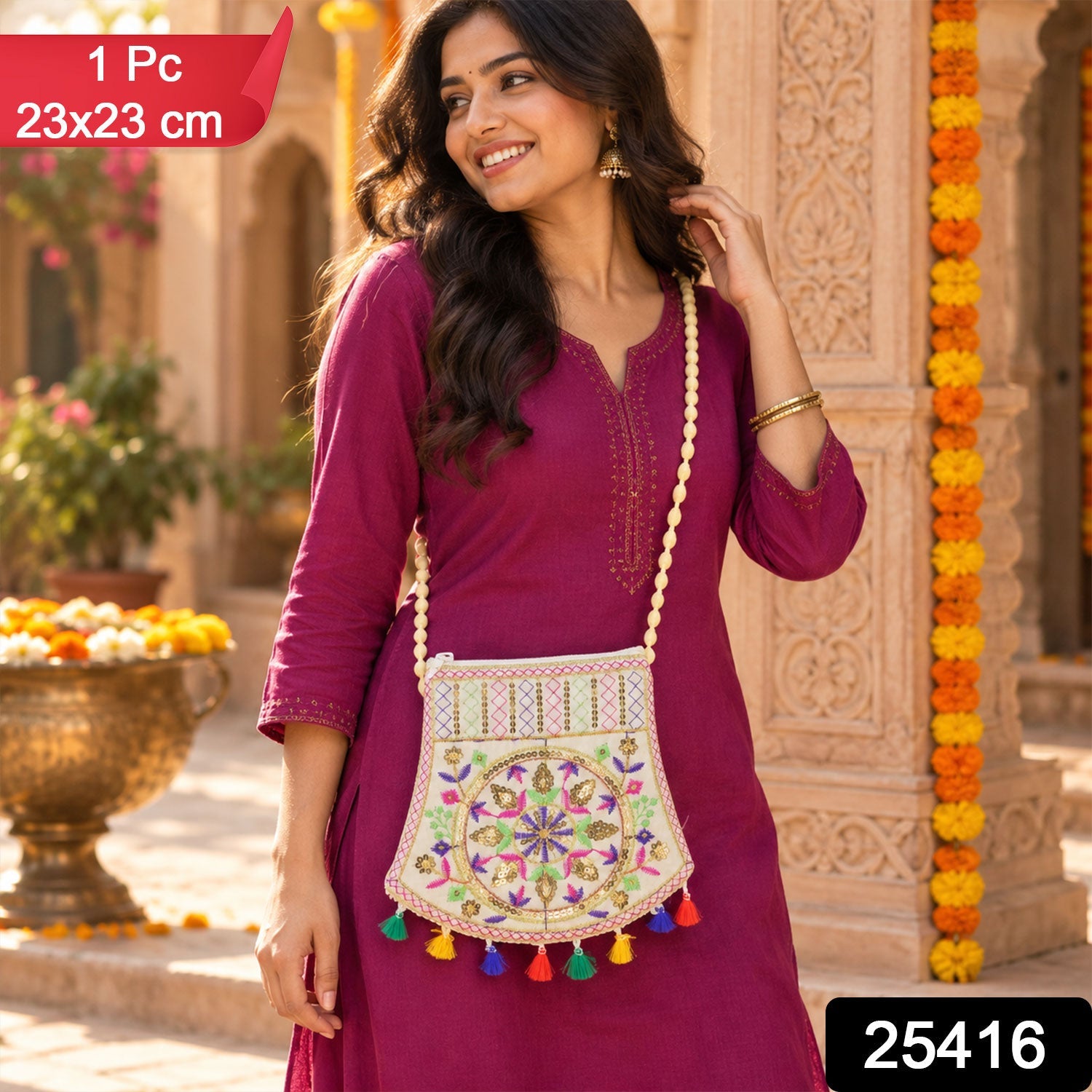 A woman in magenta holds an embroidered jute sling purse with colorful tassels and a beaded strap, smiling outdoors.
