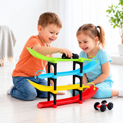Two happy children playing with a colorful four-level ramp racer toy and two small cars on a light wooden floor.