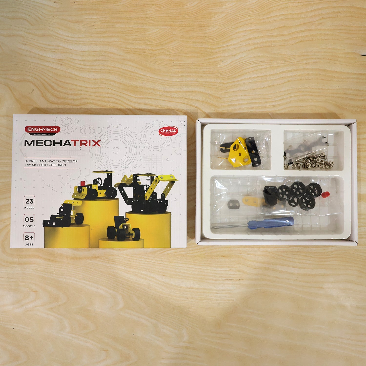 Child playing with an assembled yellow construction vehicle from the kit