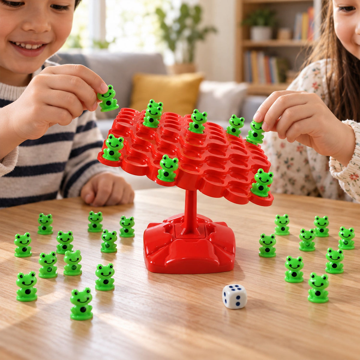Two children playing a game, carefully placing small green frog pieces onto a red balancing board with a white dice nearby.