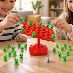 Two children playing a game, carefully placing small green frog pieces onto a red balancing board with a white dice nearby.