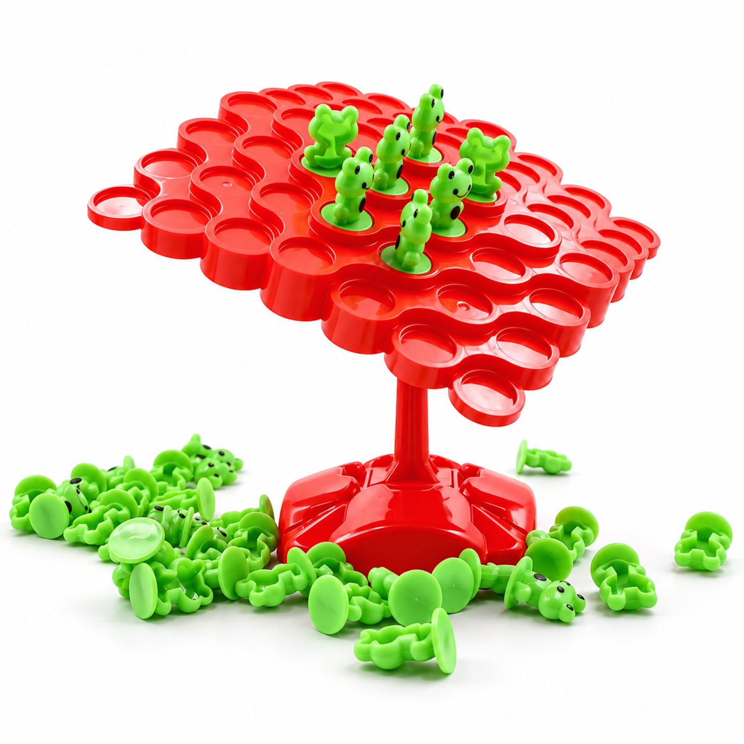 The red balancing board game with some green frogs on it, surrounded by a pile of additional green frog pieces on a white