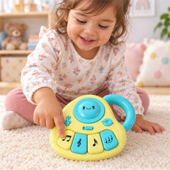 A child with a floral shirt and pink pants plays with the yellow and blue musical toy on a white rug.