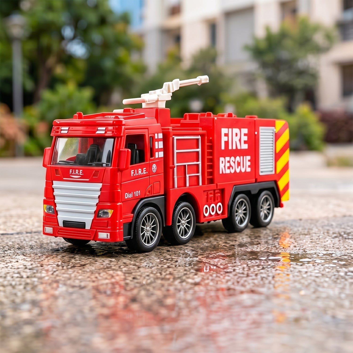 A red plastic fire truck toy with a white ladder on top, parked on a wet asphalt surface outdoors.