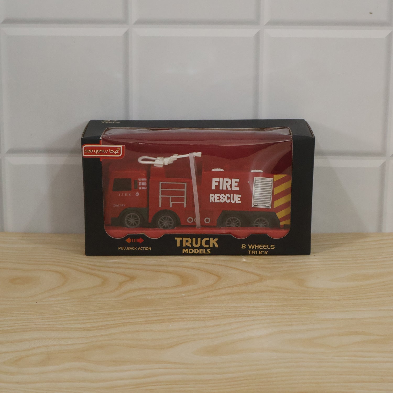 Child playing with the red plastic fire rescue truck toy indoors