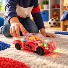 A child's hand reaches for a clear red toy truck with visible gears, glowing with colorful lights on a textured rug.