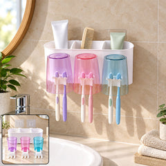 White organizer with three vibrant cups, each holding two toothbrushes, mounted on a beige tiled bathroom wall.