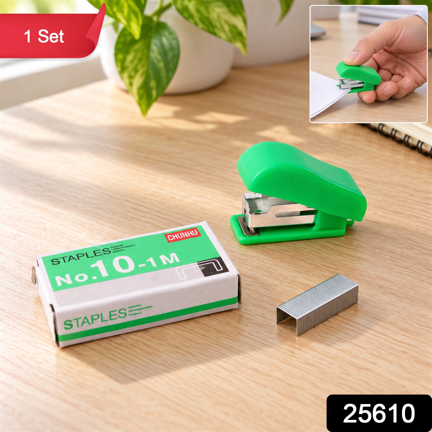 A green stapler, a box of staples, and loose metal staples are displayed on a wooden surface with a small inset image.