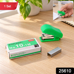 A green stapler, a box of staples, and loose metal staples are displayed on a wooden surface with a small inset image.