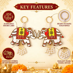 Two decorative white elephant hangings feature gold rings, pearl tassels, and "Shubh Labh" script.