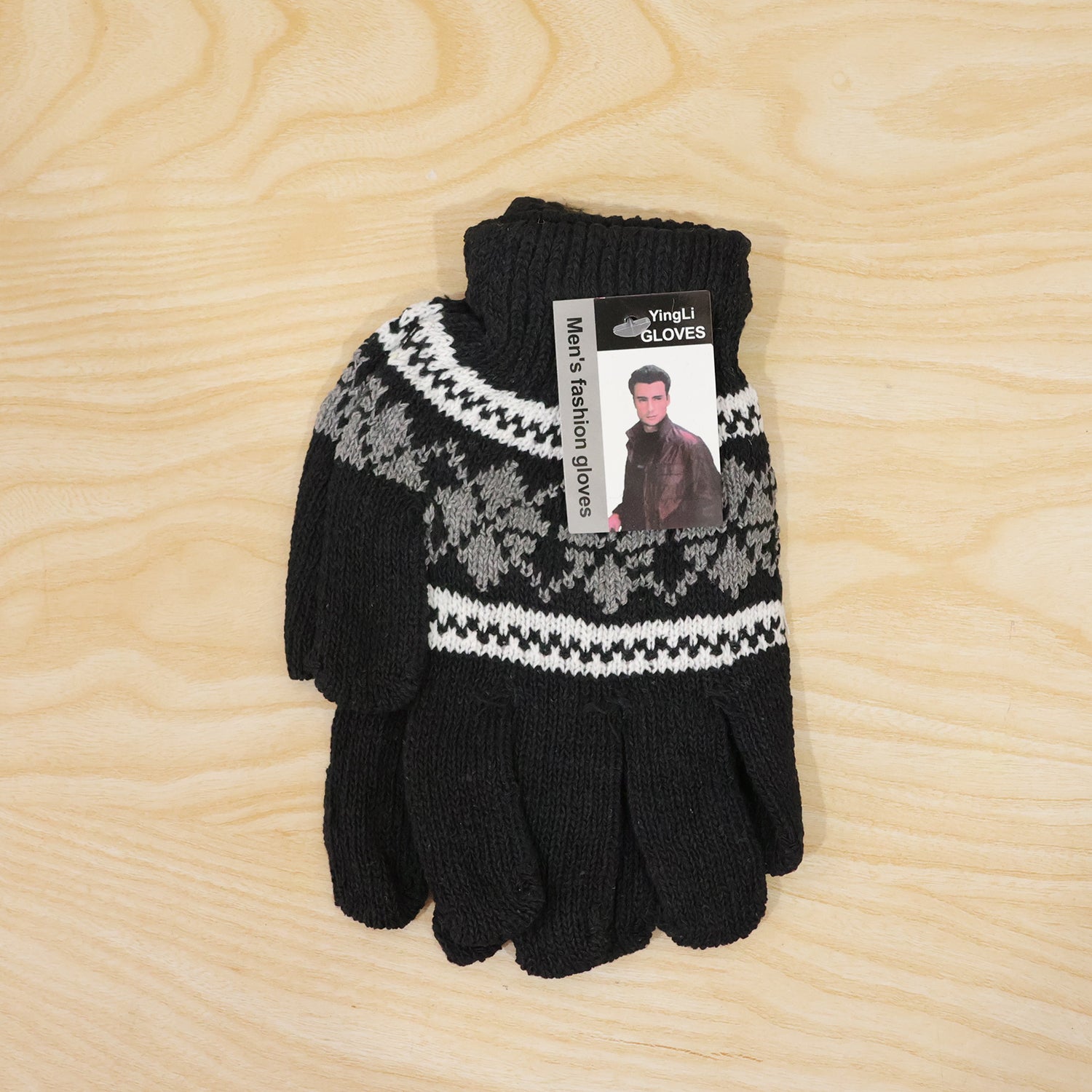Folded pair of black knitted gloves with a snowflake pattern and a