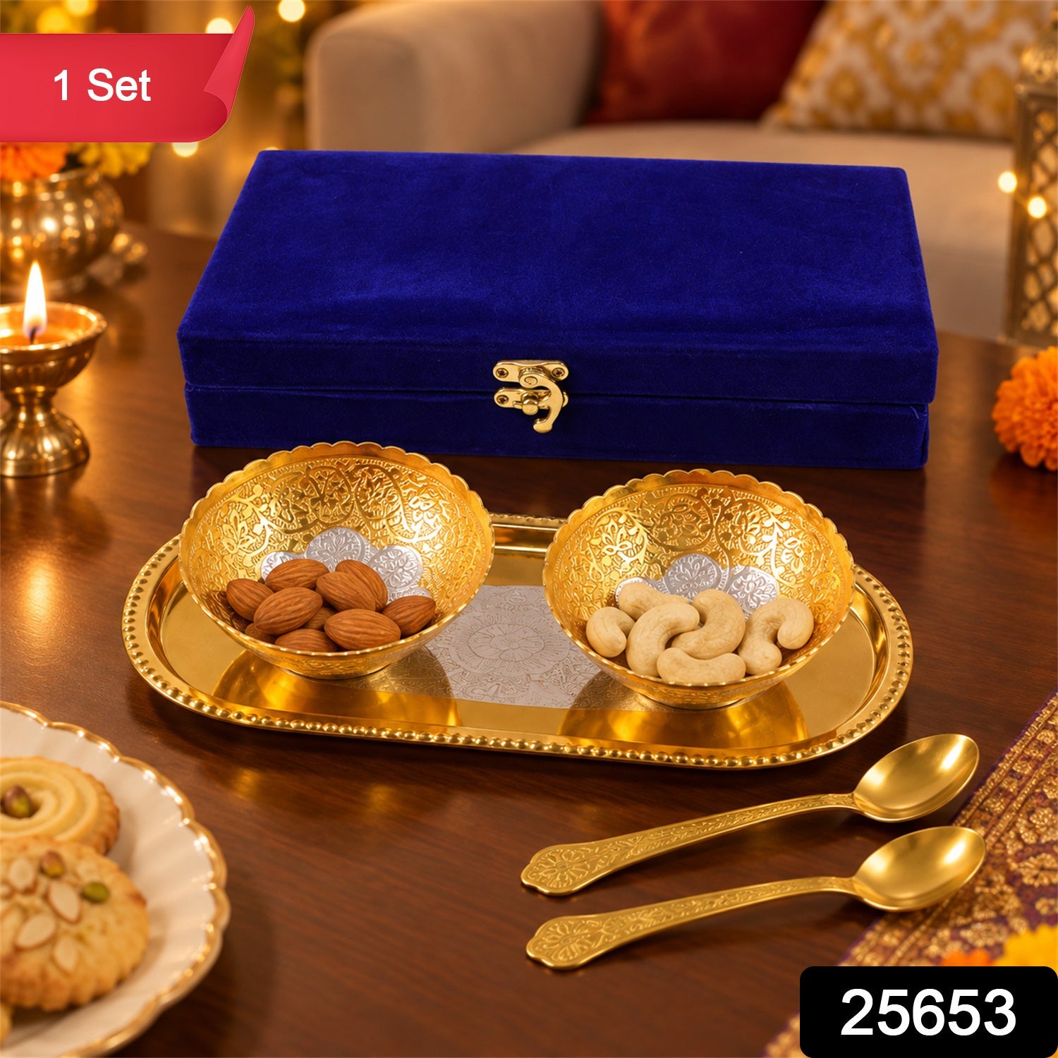 A blue velvet box, two golden bowls with nuts, a golden tray, and two small spoons on a wooden table.