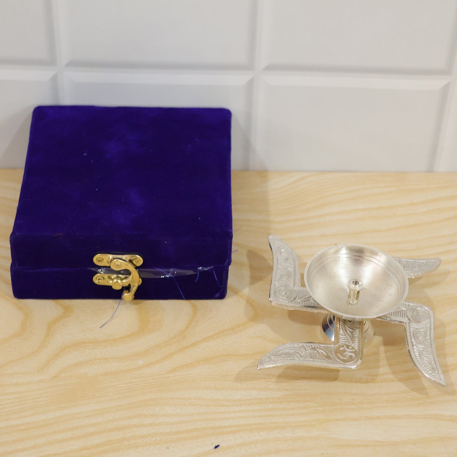 Silver finish pooja diya used as home decor in a festive setting