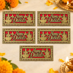 A close-up of a hand touching a red and gold Happy Diwali plaque with intricate border and deities on a wooden door.