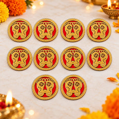 Ten circular golden Lakshmi Charan stickers with red backgrounds arranged on a light surface with festive decorations.