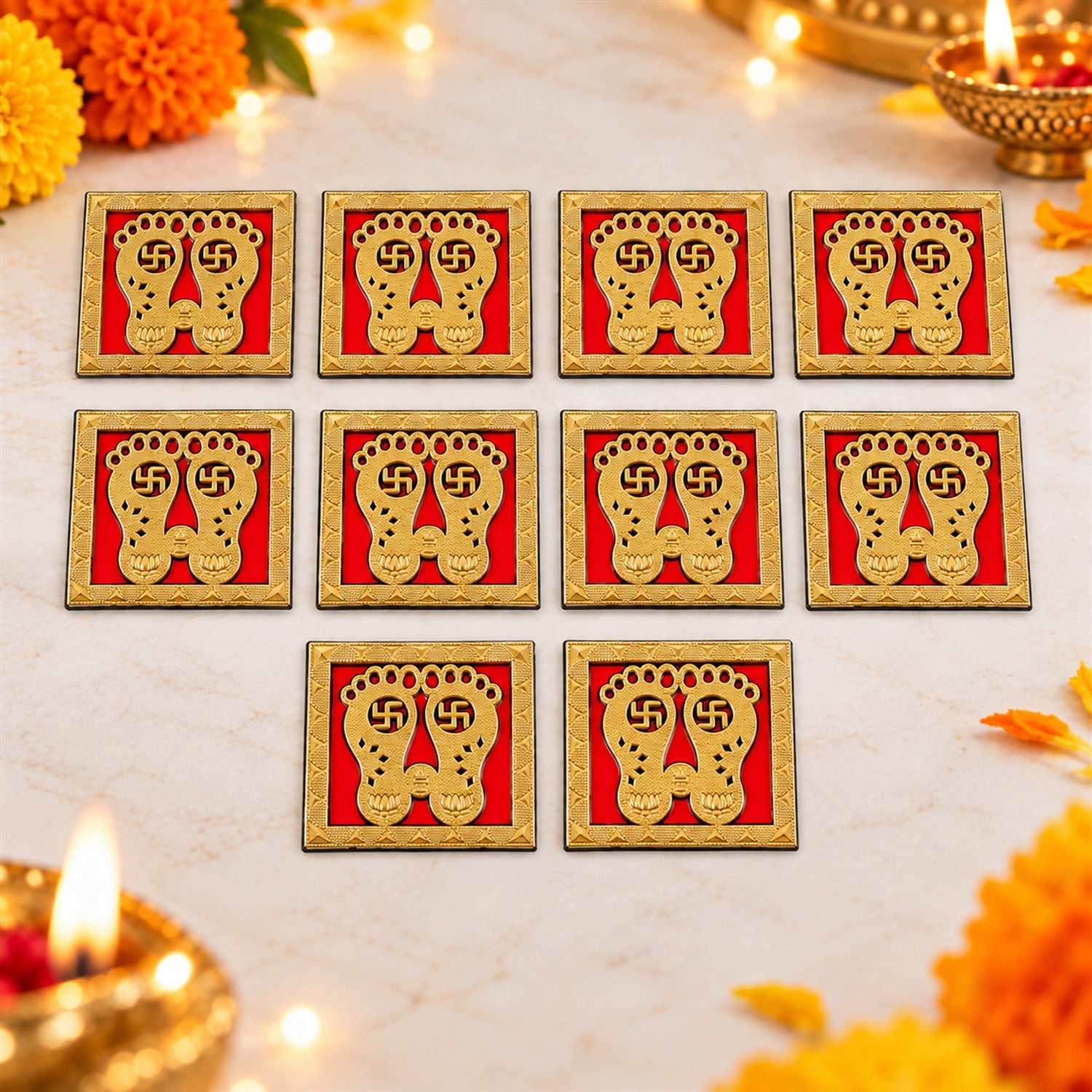 Ten golden Lakshmi Charan stickers are arranged on a light-colored surface, surrounded by vibrant marigold petals and soft