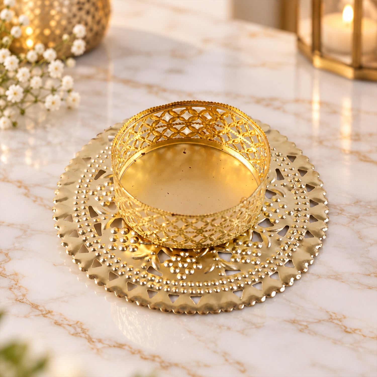 Gold tone metal jali tealight holder unlit on a simple surface