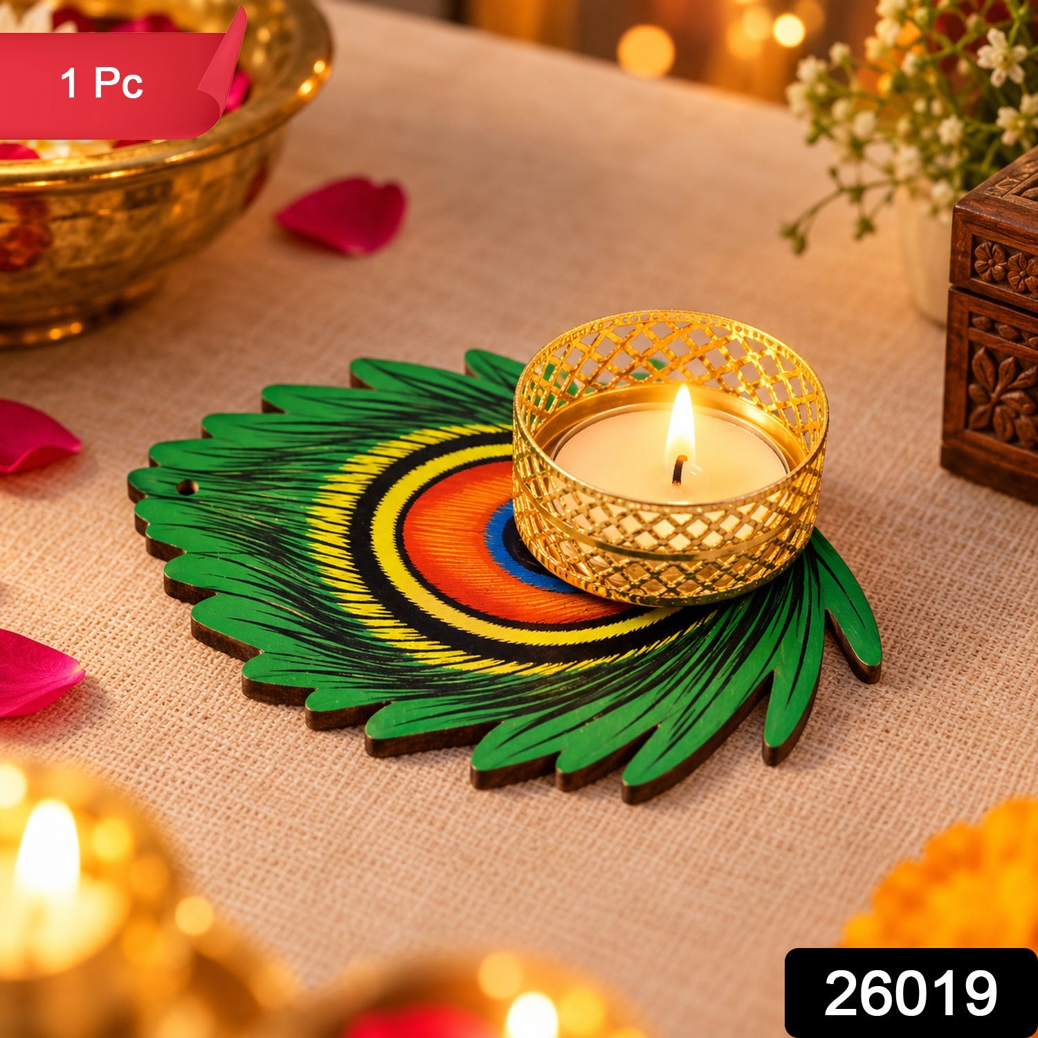 A lit tealight candle in a gold holder rests on a green peacock feather base, surrounded by festive decorations.