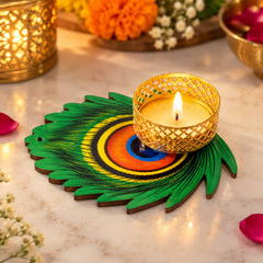 A lit candle in a gold lattice holder on a vibrant green peacock feather shaped base, surrounded by soft lights.