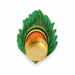 A top-down view of an empty gold tealight holder on a green and yellow peacock feather shaped base.