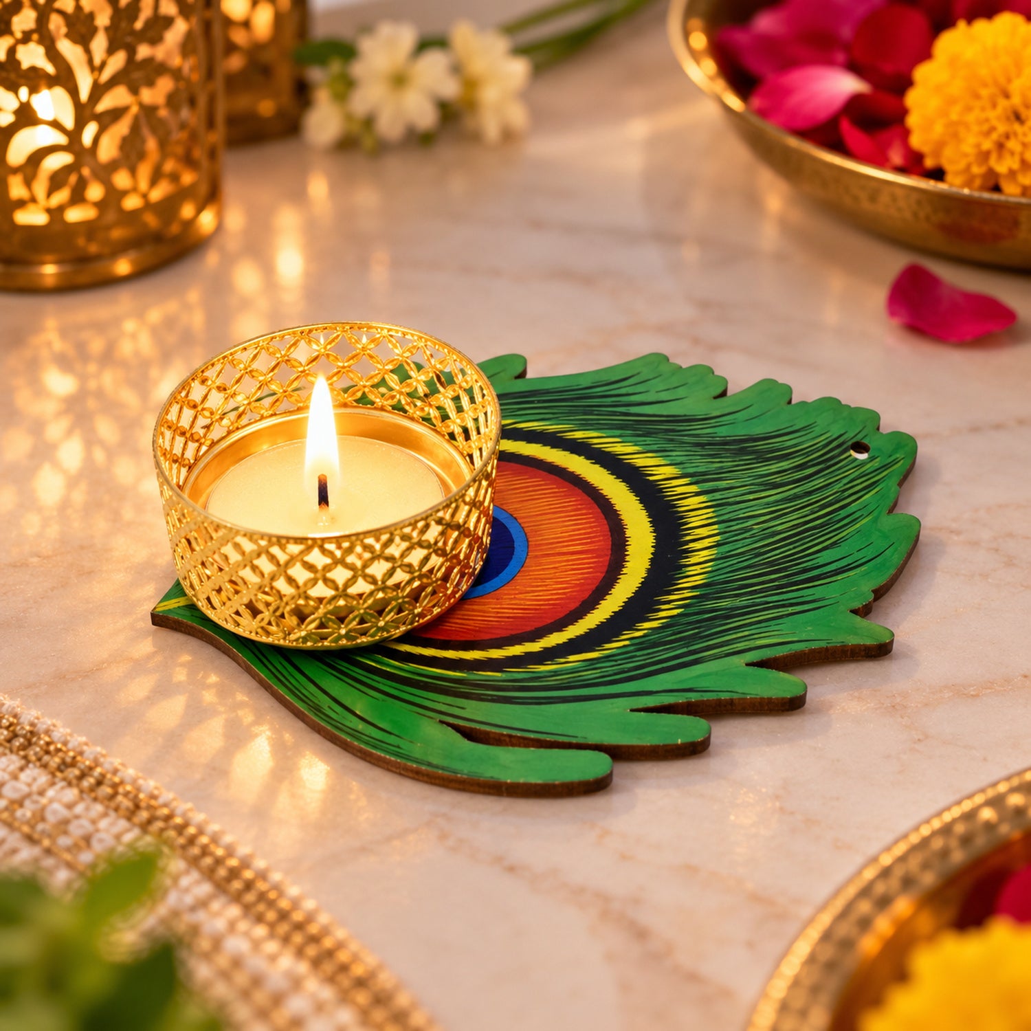 A lit tealight in a gold holder on a green peacock feather base, with decorative elements and warm lighting.