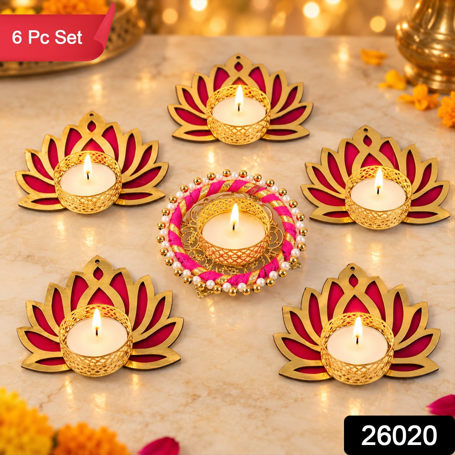 Six golden and magenta lotus-shaped tealight holders with lit candles on a marble surface, with a blurred background.