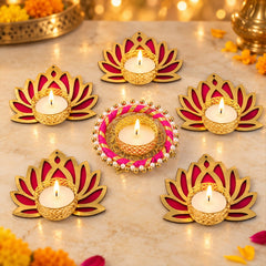 Six golden and magenta lotus-shaped tealight holders with lit candles on a marble surface, surrounded by festive lights.