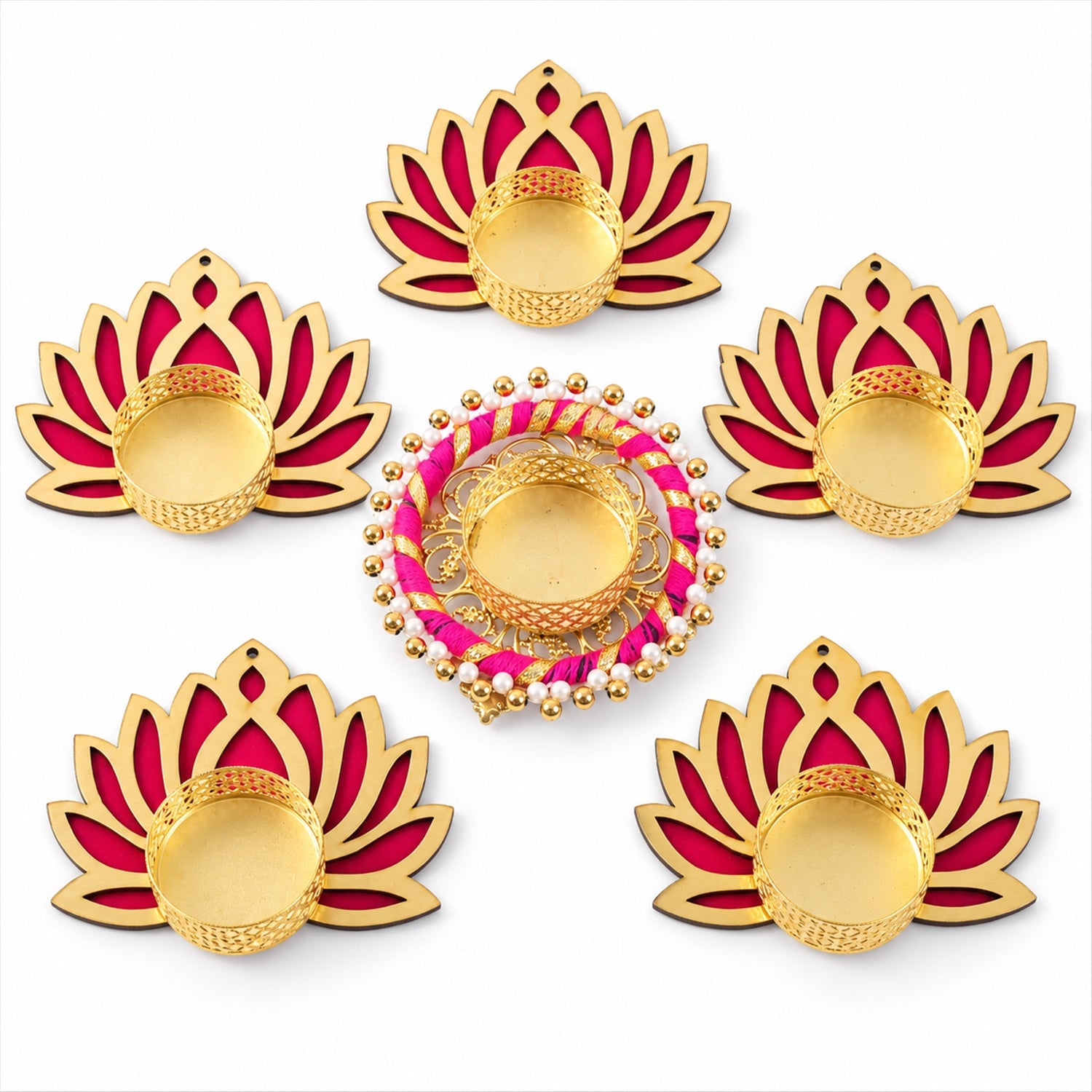 Overhead view of six golden and magenta lotus-shaped tealight holders with unlit candles on a white background.