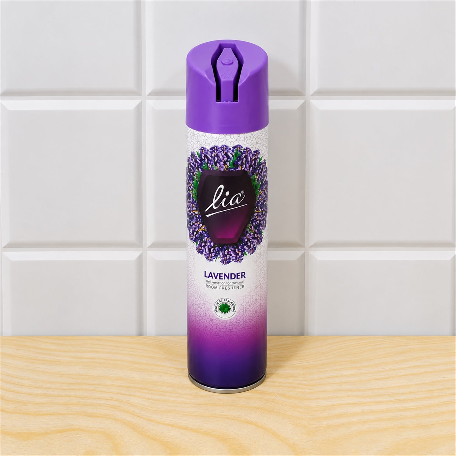 A purple and white lavender room freshener spray can stands on a light wooden surface against white tiles.