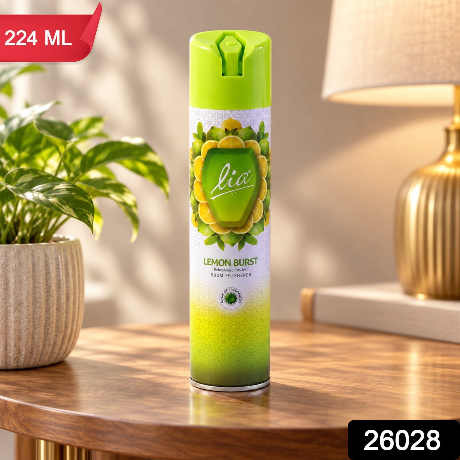 A Lia Lemon Burst room freshener spray bottle sits on a table with a plant and lamp, displaying '224 ML' and '26028' labels.