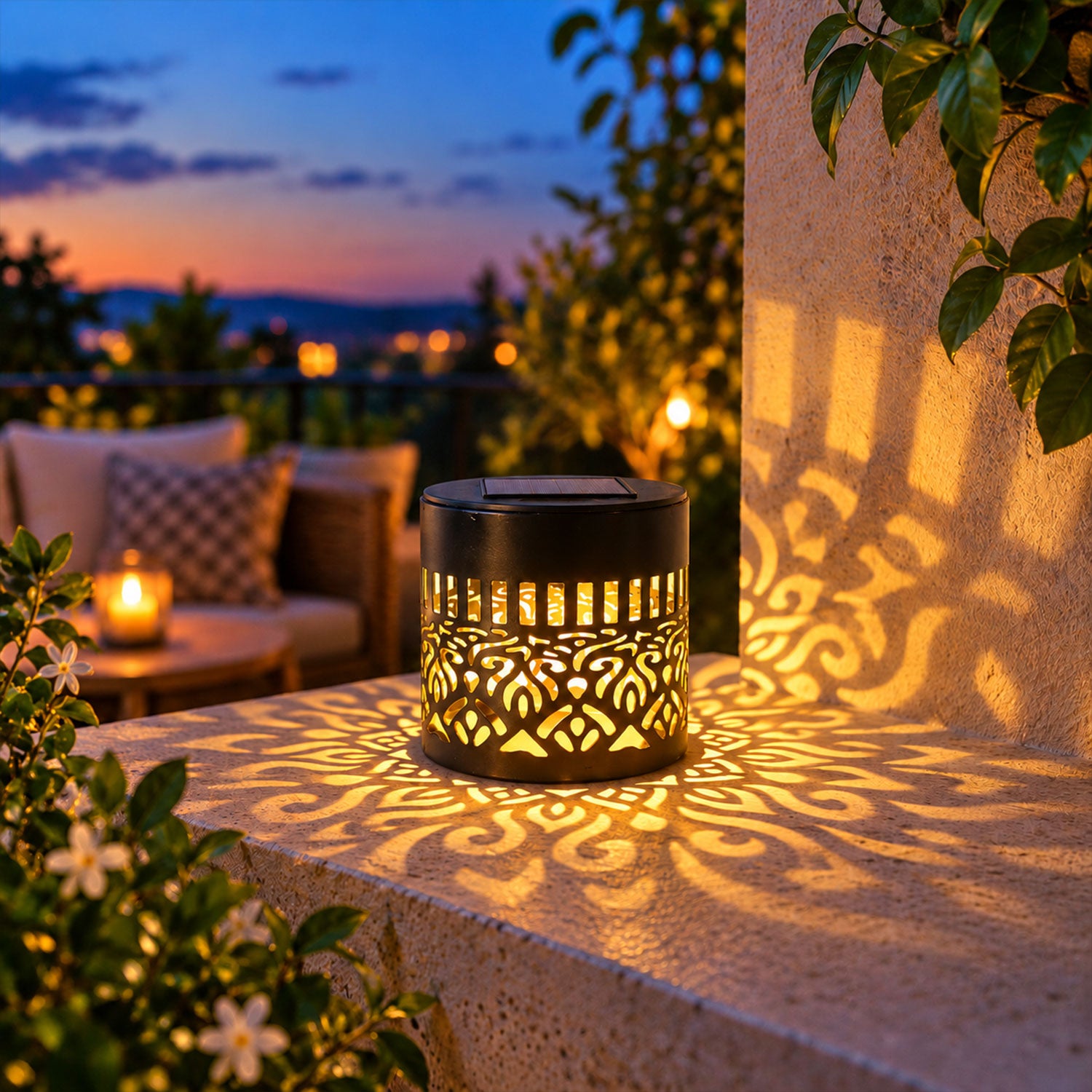 A black solar lamp with a cut-out mandala pattern casts a warm glow on a patio ledge at dusk.
