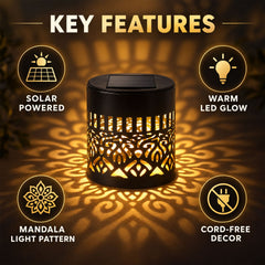 A black solar lamp with a cut-out mandala pattern casts a warm glow on a dark background.