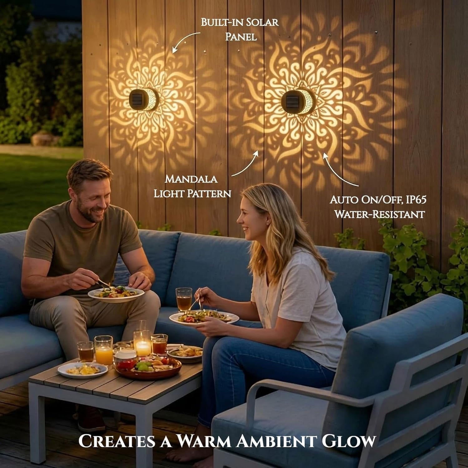 A couple dines outdoors with two black solar lamps casting mandala patterns on a wooden wall.