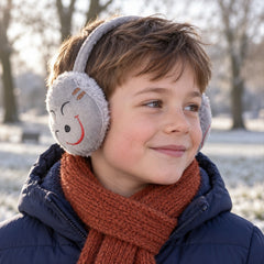 A young boy wears grey plush earmuffs with a red embroidered smiley face, a blue jacket, and an orange scarf in a snowy park.
